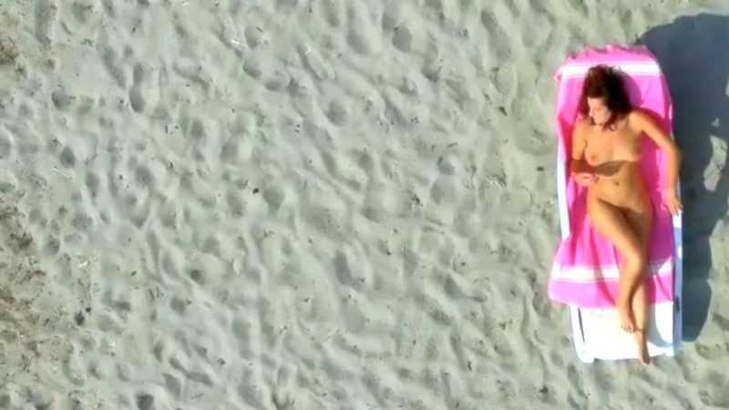 Drone spy-film af nøgen kvinde på nøgenstrand