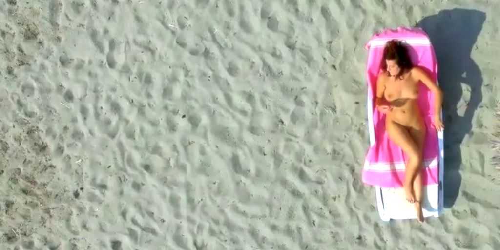 Drone spy-film af nøgen kvinde på nøgenstrand